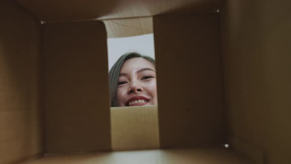 Beautiful transgender Asian woman picking things out of the box.