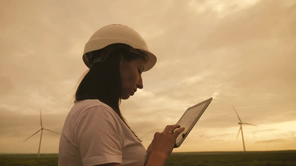 Woman Engineer Working in Wind Turbine Electricity Industrial at Sunset