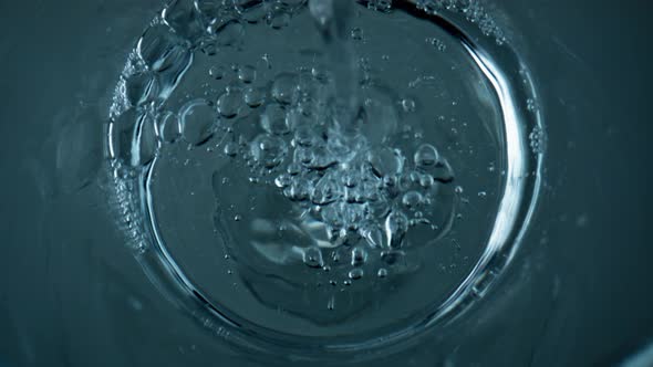 Top View Water Pouring Transparent Cup Closeup