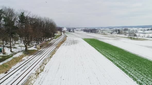 Ariel View of a Steam Engine and Passenger Cars Puffing Along Amish Farm Lands After the First Snow