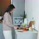 Young Woman Cooking Food While Loving Husband Chatting on Mobile Phone and Kissing Wife in Kitchen - VideoHive Item for Sale