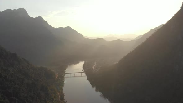 Aerial: flying over Nam Ou River Nong Khiaw Muang Ngoi Laos, sunset mountain landscape