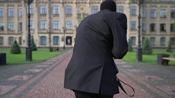 Live Camera Follows Intelligent African American Joyful Man in Suit Walking to University Campus