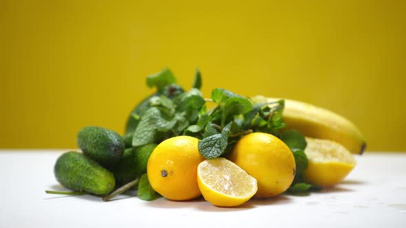 Water Droplets Falling in Slow Motion on Healthful Fruits and Vegetables at Yellow Background