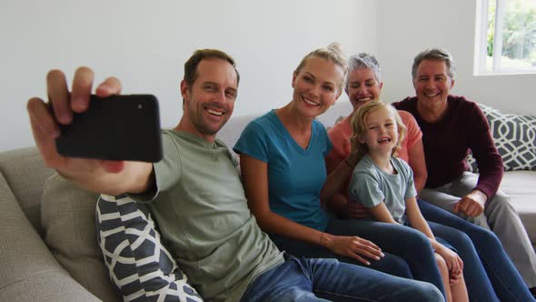 Three generation caucasian family taking a selfie together with smartphone at home