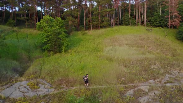 Hiking Man In Hill. Aerial shot of man walking along the hill with backpack