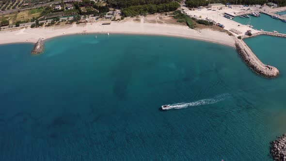 aerial view of motorboat coming out of the port