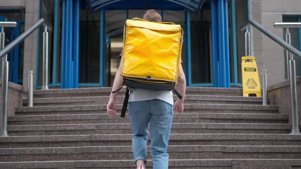 Confident Young Courier Walking Upstairs Entering Business Center in Urban City