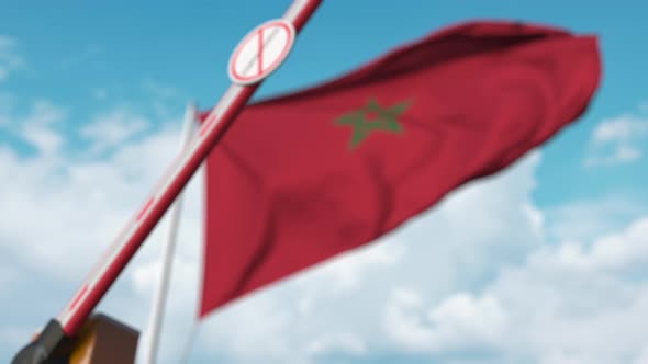 Closing Barrier with STOP CORONAVIRUS Sign Against the Moroccan Flag alt
