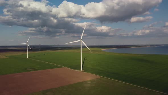 Aerial View of Wind Turbines and Agriculture Field Near the Sea at Sunset