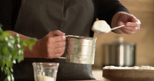 Woman sieving flour for home made Maultaschen dough