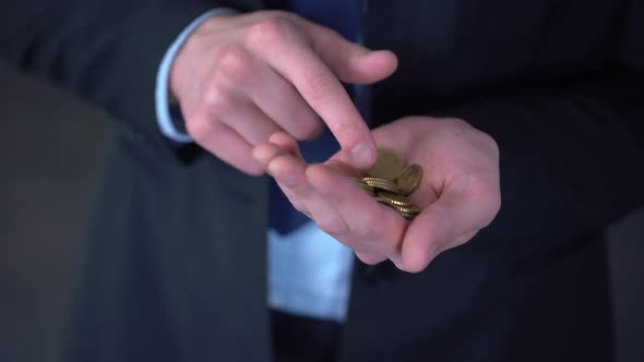 Man With Middle Income Counting Coins, Low Salary, Expenses Exceed Revenues