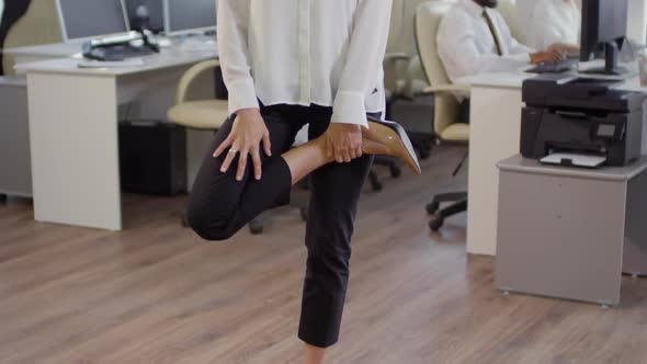 Caucasian Businesswoman Stretching Her Legs in Office