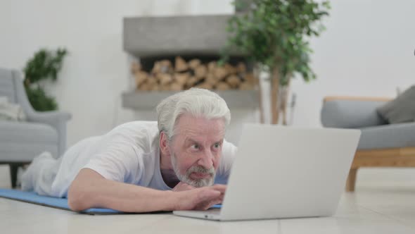 Old Man Using Smartphone Laying on Yoga Mat