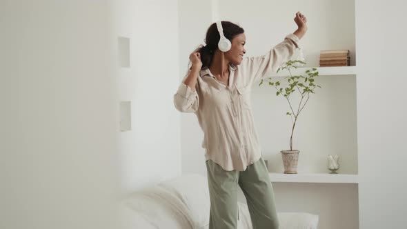 Laughing African Woman dancing on the sofa