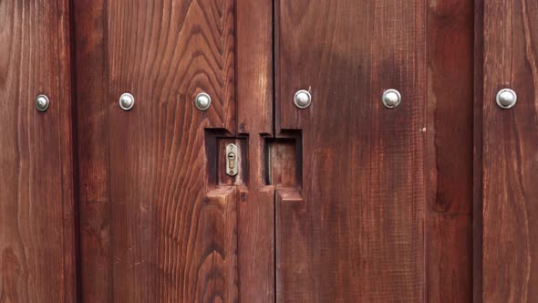 Heavy wood carved gate with rivets and a keyhole lock