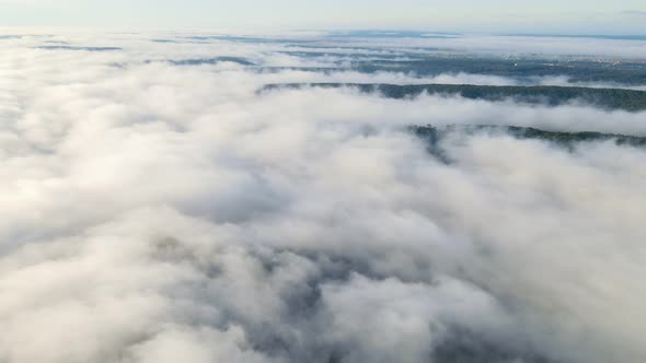 Flight Over the Mountains and Forests Covered with a Magical Morning Mist. High Flight Over the Fog