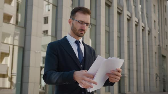 Portrait of Busy Ceo Executive Looking at Paper Documents Outside at City Background