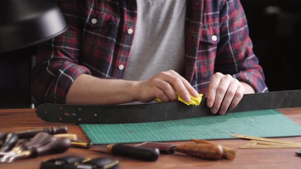 Man Tailor Cutting Artificial Leather with Ruler Closeup