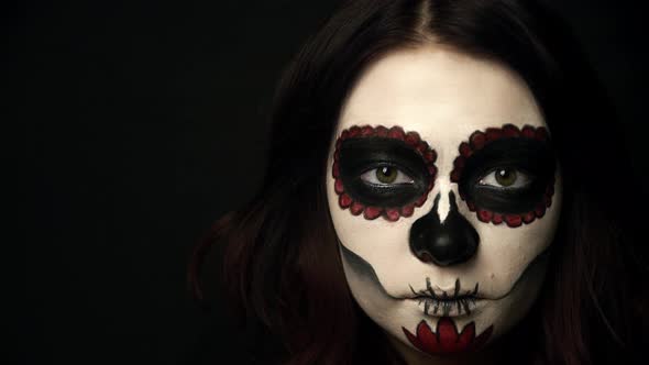 Girl with Sugar Skull Makeup Opens Green Eyes and Her Pupils Get Smaller