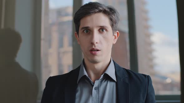 Portrait of Caucasian Millennial Scared Business Man Shocked Employee Sitting in Office Shaking