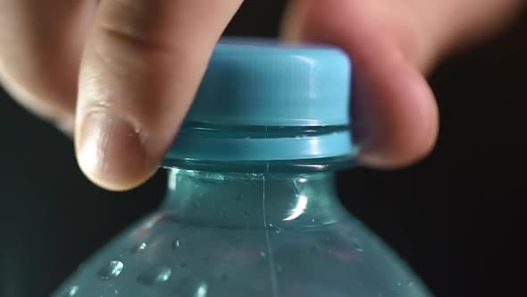 Man Opening Blue Plastic Water Bottle Cap
