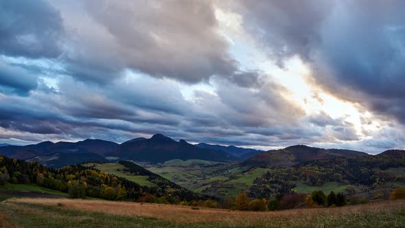 Autumn rural landscape at dusk. Thick clouds at sunset. Colorful trees in autumn.