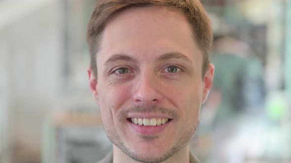 Close Up of Face of Young Man Smiling at the Camera