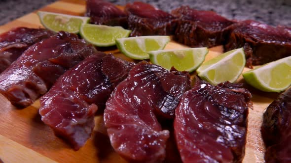 Panorama of Lightly Salted Tuna and Lime Slices Lying on a Bamboo Board