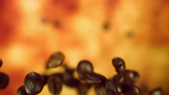 Close Up of Roasted Coffee Beans Flying on the Yellow Ocher Background