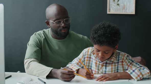 Afro-American Father Helping Son with Doing Homework at Home