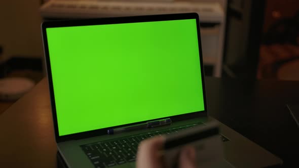 Dolly in Shot of Green Screen Laptop and Man's Hand with Credit or Debit Card