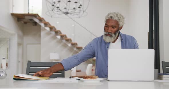 Video of african american senior man using laptop