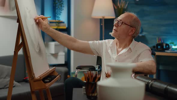 Male Artist with Chronic Impairment Drawing Vase Design on Canvas