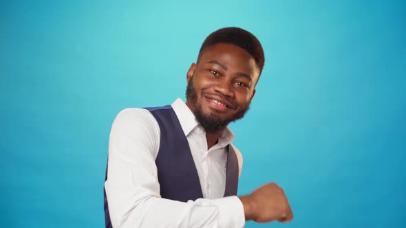 Pleased African Man in Shirt Dancing Against Blue Background