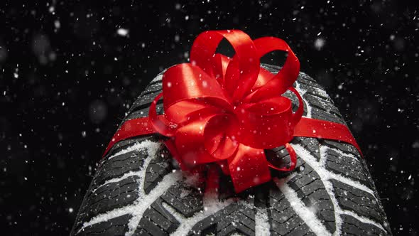 black isolation rubber tire, on the grey backgrounds in a bow for christmas