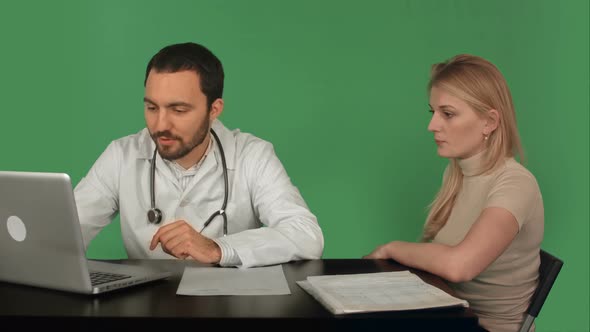 Doctor Using Laptop Discussing With Patient on a Green Screen