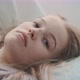 Close up young blonde woman looking bored while laying on her back - VideoHive Item for Sale