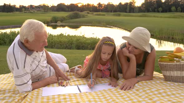 Little Girl Drawing with Grandparents.