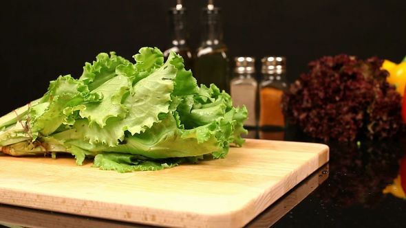 Lettuce and Parsley Fall On A Cutting Board
