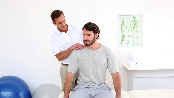 Physiotherapist Touching Patients Injured Shoulder