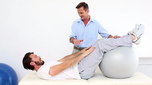 Physical Therapist Helping His Patient Do A Sit Up alt