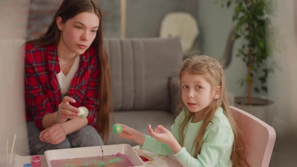 Girl Talks to Sister Coloring Eggs for Easter at Video Blog
