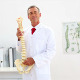 Smiling Doctor Explaining Model Of Spine To Camera - VideoHive Item for Sale