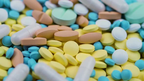 A Red Lid From a Test Jar Drops on Multi-colored Tablets