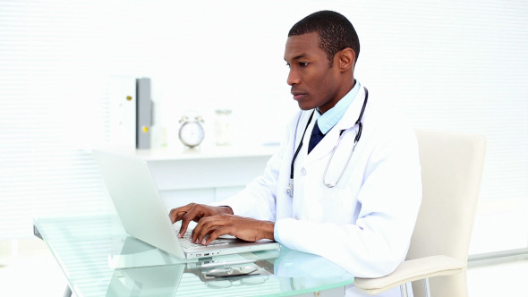 Serious Doctor Working On His Laptop