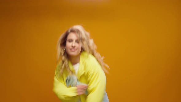 Woman Professional Dancer Dancing in Studio Against Yellow Background