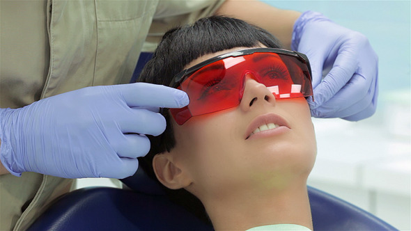 Girl In Dental Chair With Protective Red Glasses