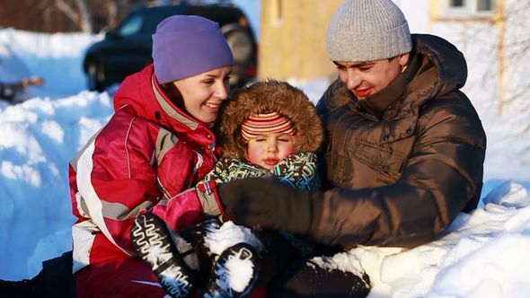 Happy Couple With A Child In Winter