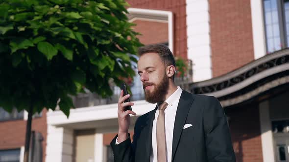 Successful Businessman Dressed in Formal Suit with Tie Speaking on the Mobile Phone